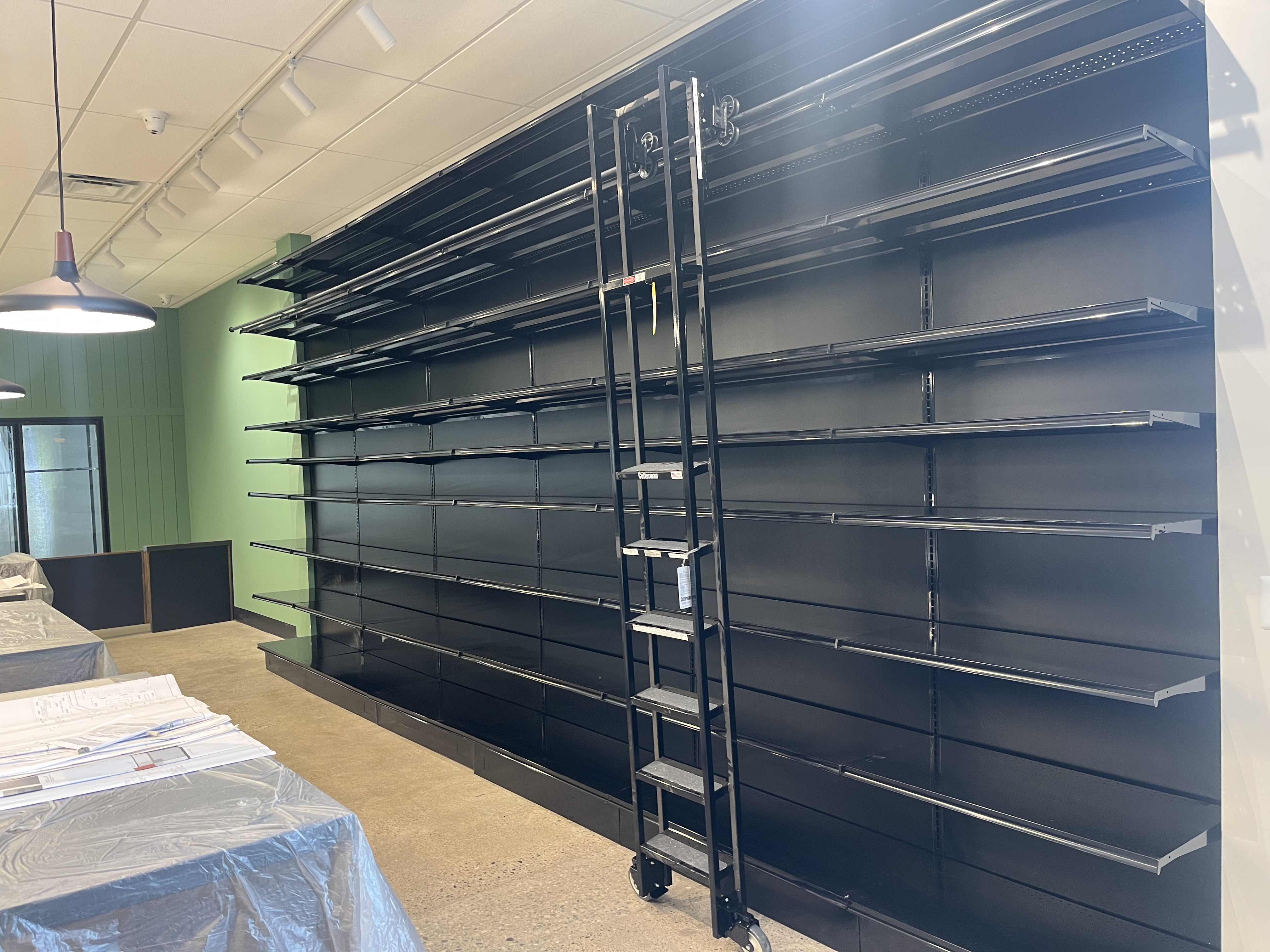 Full-height liquor wall shelving with rivet shelving